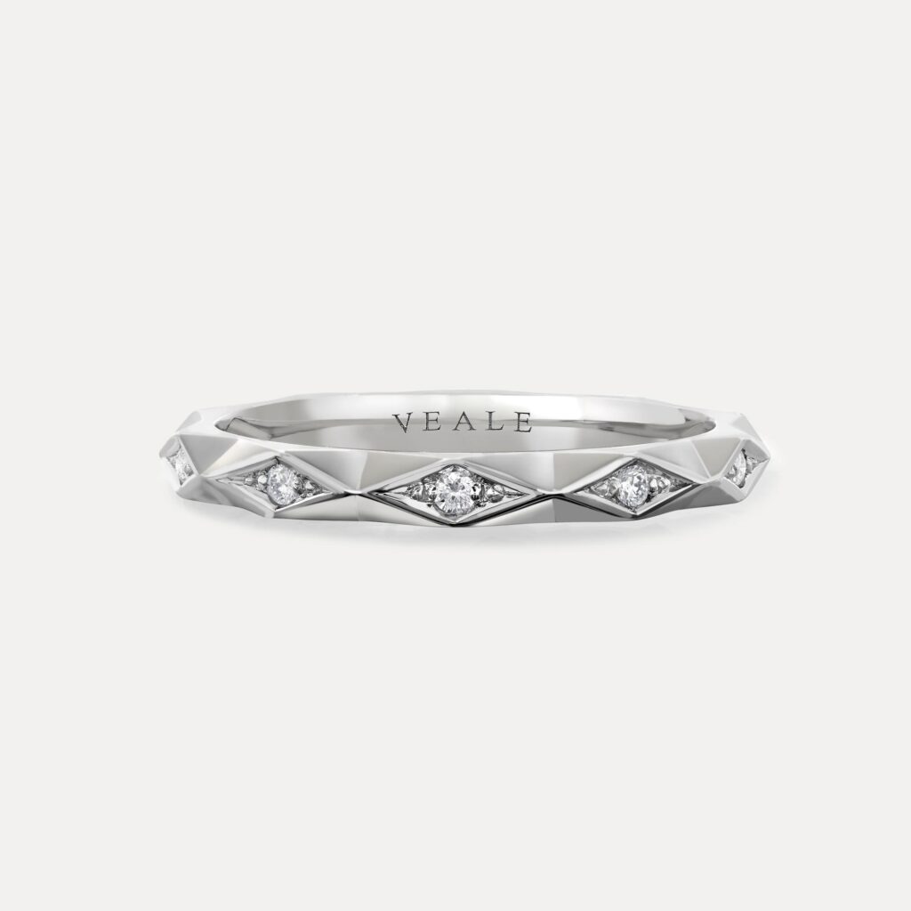 Geometric inspired stacking ring with round brilliant diamonds and faceted edges