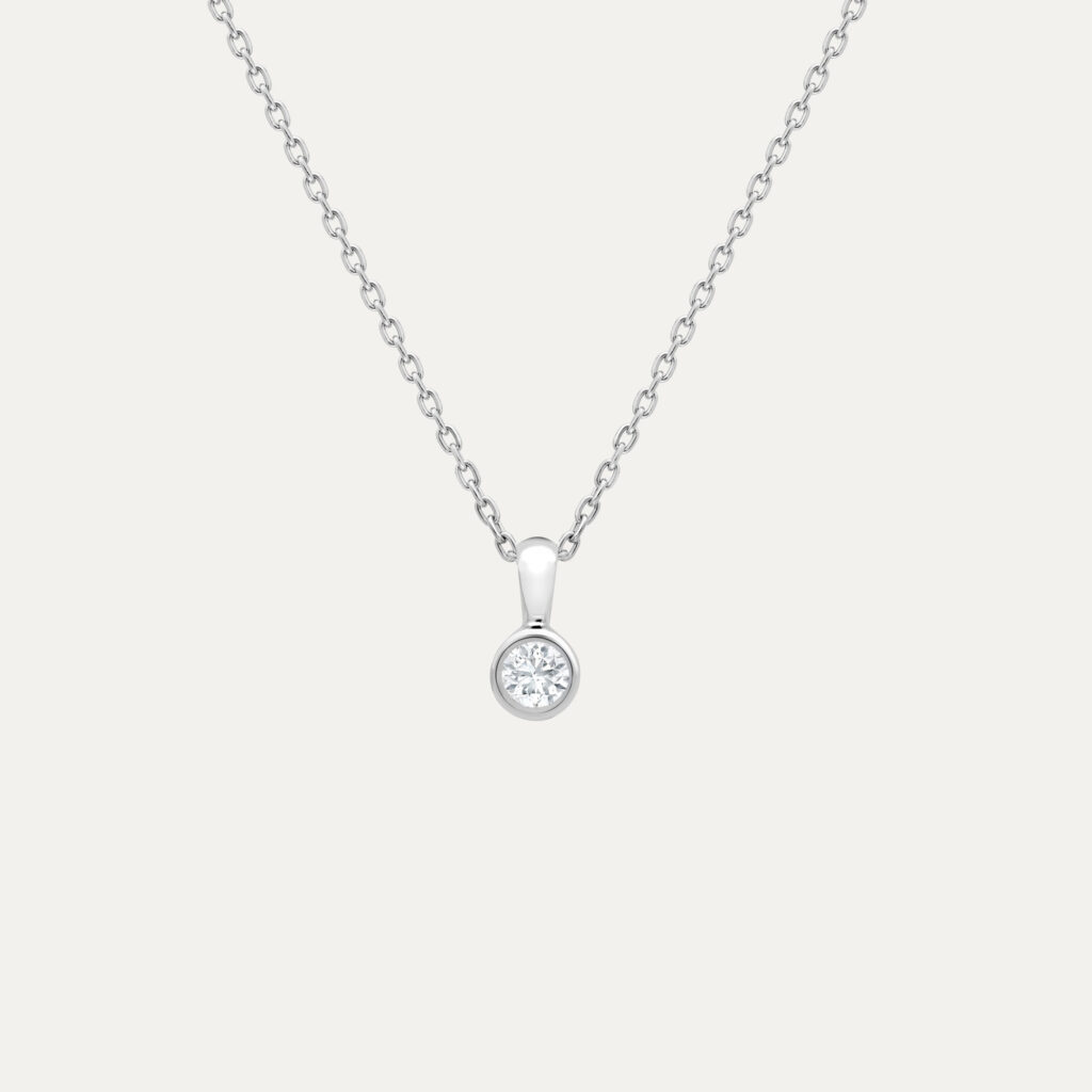 A fine platinum chain set with a dainty bezel set round brilliant cut diamond