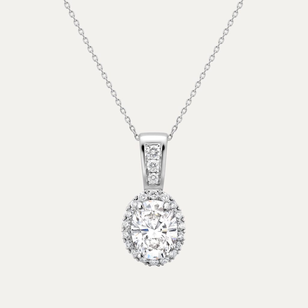 Oval cut diamond set in Knightsbridge halo setting surrounded by round diamond on a fine platinum chain