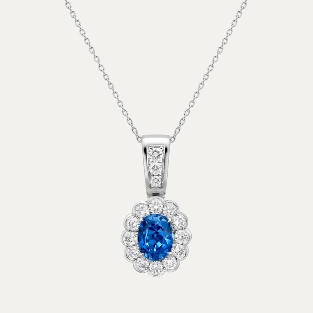 Velvet sapphire necklace set with a central oval Ceylon sapphire and surrounded by a cluster of round cut diamonds
