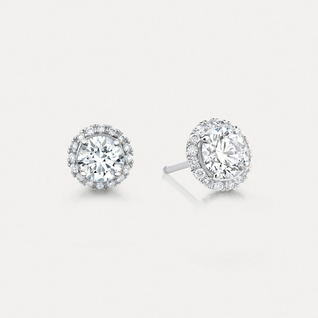 Diamond Halo stud earrings set with a central round diamond and a fine surround of smaller diamonds.