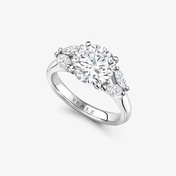 Platinum Engagement ring set with a round brilliant cut diamond and 4 marquise cut diamonds in a flower design