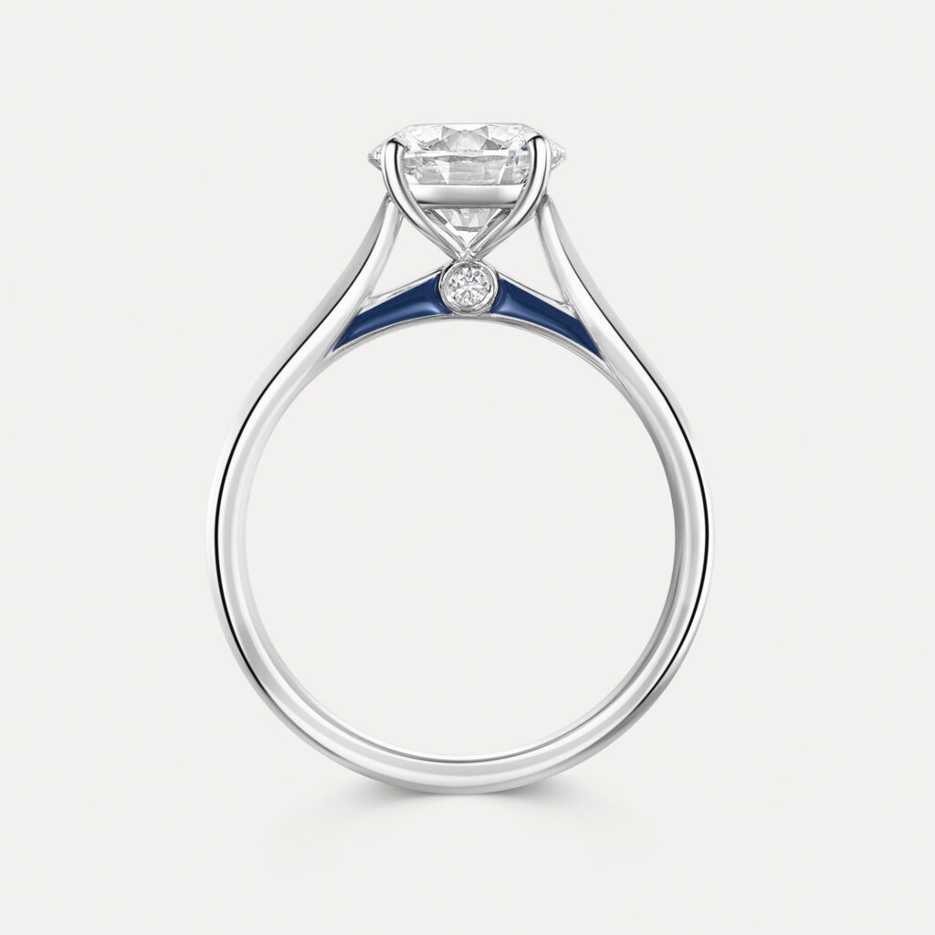 Round brilliant-cut diamond held in platinum with navy enamel along the side profile of the ring's finger with a small accent stone in a bezel setting