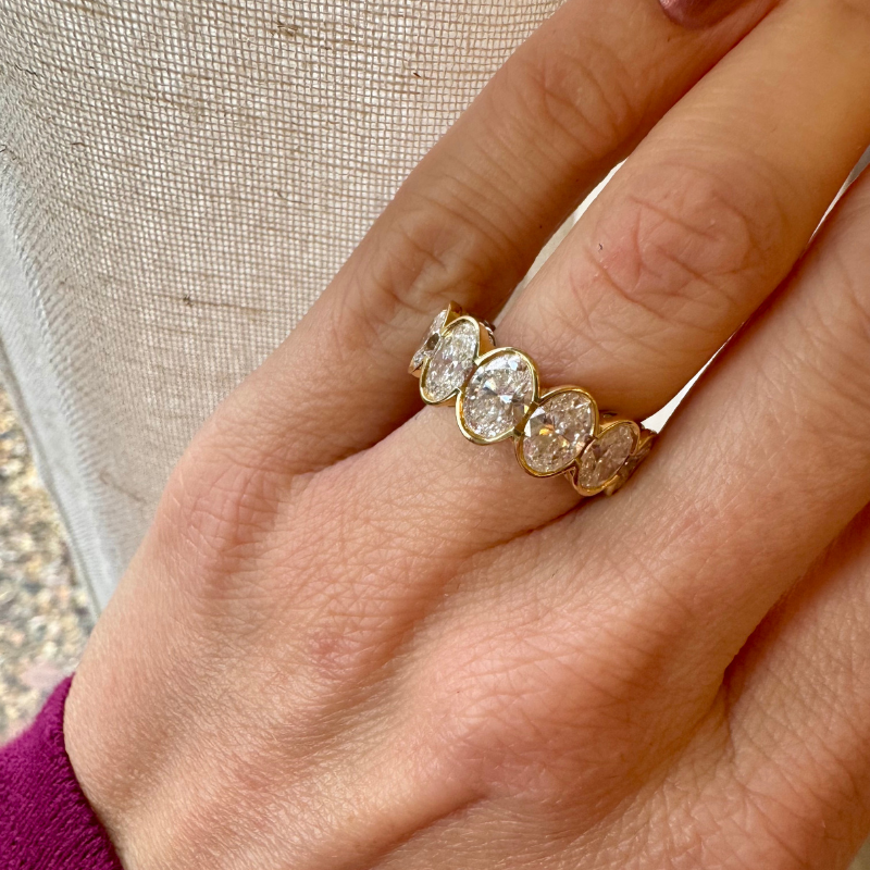 Oval-cut diamond eternity ring on hand